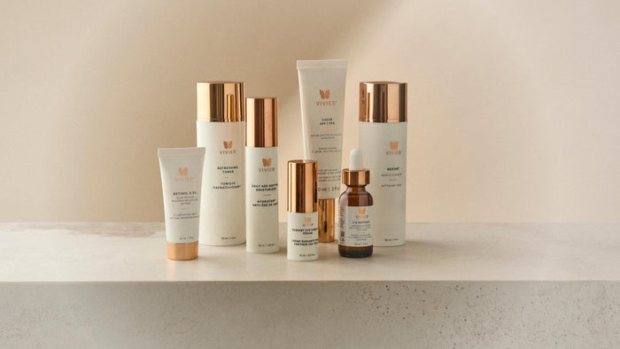 Collection of Vivier skincare products displayed on a stone surface, including cleanser, toner, serum, moisturizer, eye cream, retinol, and sunscreen.